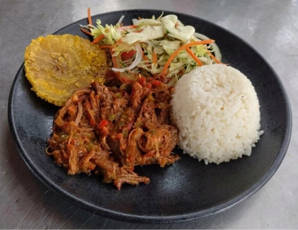 Menú ejecutivo con carne desmechada, arroz, patacón y ensalada en Akí es la Vuelta